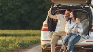 casal tirando uma foto na traseira de um carro, representando a contratação de um seguro automóvel