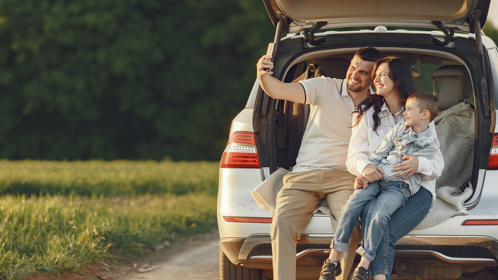 casal tirando uma foto na traseira de um carro, representando a contratação de um seguro automóvel