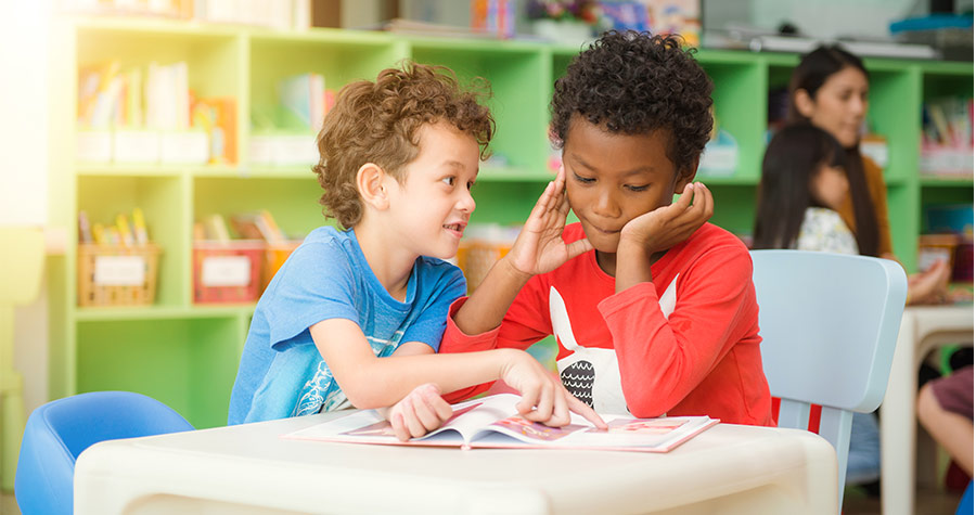 Meninos estudando com a proteção do seguro escolar